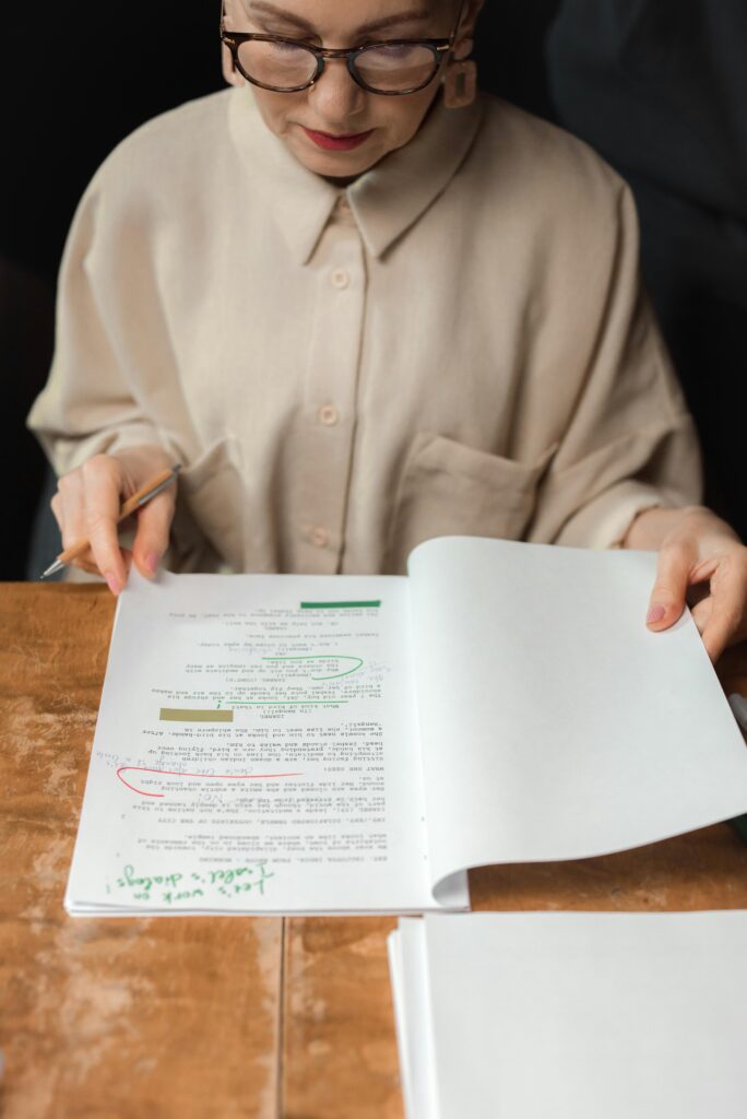 pexels-photo-7967580-7967580 Senior woman reviewing a screenplay script with notes and edits, showcasing expertise.